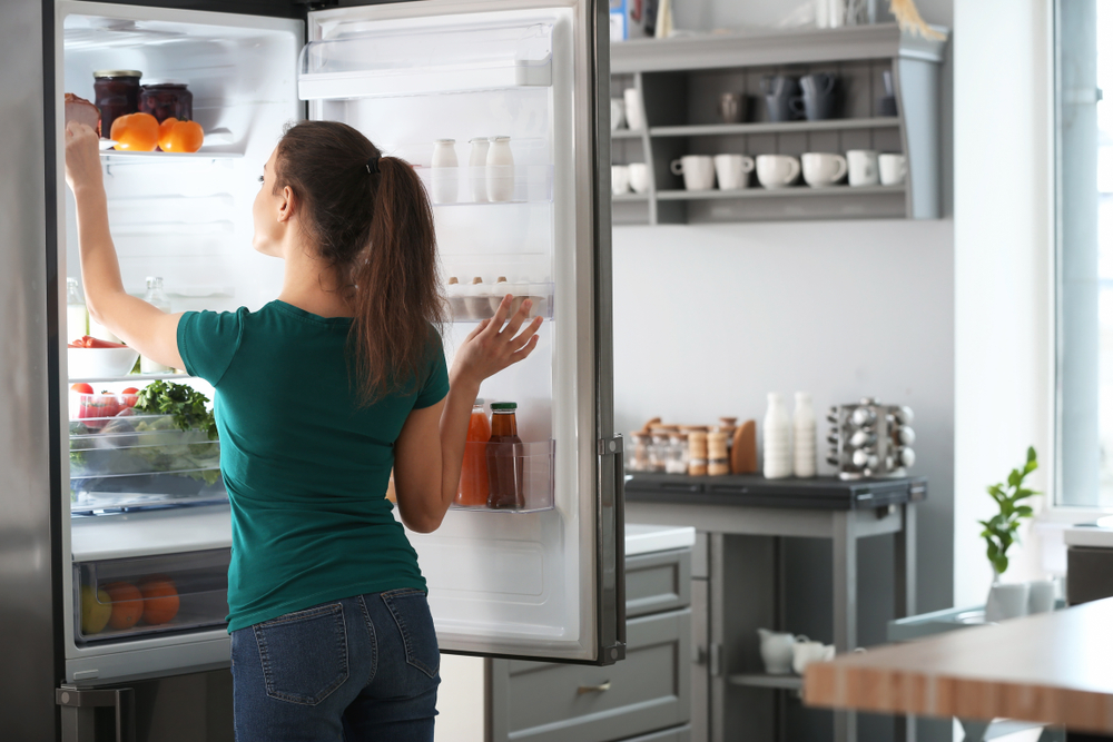 woman taking something out of the fridge